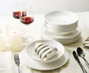 A table setting with plates, bowls, cutlery, wine glasses, and candles. Anteprima dell’immagine prodotto
