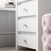Close-up of white drawers with crystal knobs, part of a vanity or dresser. Produktbild-Vorschau