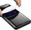 A hand is holding a white UV curing light over a smartphone screen, with blue lights emitting from the curing light. Náhľad obrázku produktu