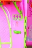 A close-up view of a pink toy cottage with green accents, showing decorative elements like flower-shaped hooks and toy keys. Produktbild-Vorschau