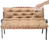 A hand is pouring water onto a taupe bench cushion to demonstrate its water-repellent properties. Náhled obrázku produktu