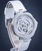 A close-up studio shot of a women's wristwatch with a white strap and a silver, skeletonized dial. Náhled obrázku produktu