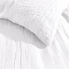 A close-up view of white, crinkled fabric, likely bedding. Produktbild-Vorschau