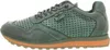 A side view of a green sneaker with an orange sole. Voir les images du produit