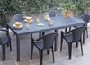 An outdoor patio setting with a dark grey rattan-look table and chairs, set for a meal with drinks and snacks. Produktbild-Vorschau