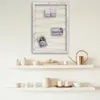 A decorative photo frame with string and clips, displayed on a wall above two shelves with various decorative items. Produktbild-Vorschau