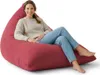 A woman sits on a large red beanbag chair. Voir les images du produit