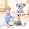 A young child is playing with a stacking toy on the floor. Voir les images du produit