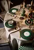 A beautifully set dining table for a festive occasion, likely Christmas, with dark green plates, gold cutlery, candles, and festive decorations. Produktbild-Vorschau