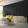 A modern living room with a sectional sofa, coffee tables, and a large plant, with a textured black wall in the background. Produktbild-Vorschau