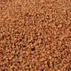 A close-up, overhead view of brown, granular sprinkles. Produktbild-Vorschau