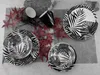 A set of black and white patterned plates and mugs are arranged on a textured surface with red leaves. Náhľad obrázku produktu