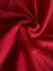 A close-up view of red fleece fabric, showing its texture and folds. Produktbild-Vorschau
