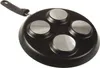 The underside of a black frying pan with four circular silver inserts and a black handle. Voir les images du produit