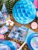 A collection of Lilo & Stitch themed party supplies, including party hats, cups, napkins, and decorative honeycomb balls, arranged on a wooden surface. Podgląd zdjęcia produktu