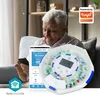 An elderly man is sitting on a couch, looking at his smartphone, with a smart pill dispenser next to him. Anteprima dell’immagine prodotto