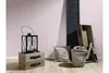 A decorative arrangement of items including a lantern, wooden crates, a pillow, a basket with a blanket, and a large wooden letter 'A' against a pink wall and wooden floor. Produktbild-Vorschau