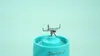 A close-up shot of the blades of a teal blender. Náhľad obrázku produktu