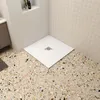 A modern bathroom corner with a white shower tray on a terrazzo floor. Produktbild-Vorschau