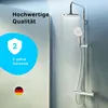A shower system with a rain shower head and a handheld shower head, with water spraying from the rain shower head. Text overlays highlight quality and warranty. Produktbild-Vorschau