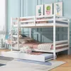 A white bunk bed with a pull-out trundle bed in a room with blue paneled walls and cactus artwork.
