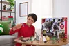 A young boy is playing with dinosaur toys in front of an advent calendar. Produktbild-Vorschau