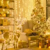 A festive Christmas scene with a decorated tree, a reindeer figure, and wrapped gifts, all illuminated by fairy lights. Náhled obrázku produktu