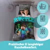 A young boy is lying in a bed with Minecraft-themed bedding. Produktbild-Vorschau