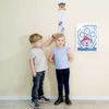 Two children are standing next to a height chart in a room. Náhľad obrázku produktu