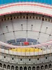 A model or illustration of the Colosseum in Rome, showing the arena floor with figures, and the seating areas filled with spectators. Produktbild-Vorschau