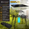 A camping table and its accessories are displayed outdoors on grass, with a camper van in the background. Produktbild-Vorschau