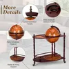 A globe bar cart with a globe on top, displayed in a living room setting with furniture in the background. Náhled obrázku produktu
