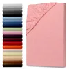 A pink fitted sheet is shown on the right, with a stack of fitted sheets in various colors on the left. Produktbild-Vorschau