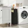 A narrow black cabinet with drawers and baskets is placed between a white vanity and a white washing machine in a laundry room or bathroom. Náhled obrázku produktu