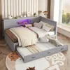 A bedroom scene featuring a grey corner bed with a pull-out trundle bed, decorated with pillows and a swan figurine. The bed has integrated LED lighting. Podgląd zdjęcia produktu