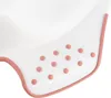 A close-up view of the edge of a white baby potty seat with pink trim and pink polka dots. Anteprima dell’immagine prodotto
