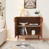 A sideboard with its doors open, displaying items on its shelves, placed in a room next to a sofa. Podgląd zdjęcia produktu