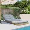 A lounge chair with a gray cushion is placed on a tiled patio next to a swimming pool, with a wooden fence and lush greenery in the background. Voir les images du produit