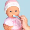 A close-up of a Nenuco Sara doll being fed with a blue spoon. Produktbild-Vorschau