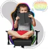 A young boy sitting in a gaming chair, holding a book. Anteprima dell’immagine prodotto