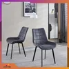Two gray dining chairs with quilted upholstery and black metal legs are shown in a modern living room setting. Náhľad obrázku produktu