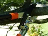 A close-up of pruning shears cutting a tree branch. Produktbild-Vorschau