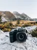 A black Kodak Pixpro AZ405 camera rests on a rocky surface with a mountainous landscape in the background. Náhled obrázku produktu