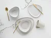 A flat lay of a dinnerware set with gold cutlery on a white background. Náhľad obrázku produktu