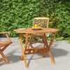 A wooden folding table and chairs set in a garden setting. Podgląd zdjęcia produktu