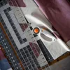 A close-up view of quilting tools including a rotary cutter and rulers laid out on fabric. Produktbild-Vorschau