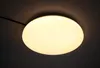 A close-up shot of a round, white LED ceiling light mounted on a dark ceiling. Produktbild-Vorschau