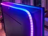 The back of a television with LED light strips attached to the edges, casting colorful light. Anteprima dell’immagine prodotto