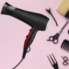 A black and red hairdryer is laid out on a pink background with various hair styling tools. Produktbild-Vorschau