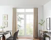 A dining area with a table, chairs, and a large window with curtains. Produktbild-Vorschau